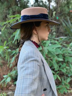 Inspired in the Gaucho hat from the Patagonia, this camel brown wool felt fedora hat is handmade in Spain, exclusively for Cuckoo B, by hat makers since 1935. It features a stylish wide brim, navy blue velvet ribbon band, and leather chin strap. Material: 100% wool, velvet band Crown size: Adjustable inner band Size: 14 x 15 x 3 1/4 inches Brim width: 3 1/2 inches HANDMADE IN SPAIN Due to their handmade craftsmanship, hats can vary slightly in size and color, and have some imperfections, which i Luxury Brown Felt Hat With Short Brim, Luxury Wool Boater Hat With Curved Brim, Brown Curved Brim Hat With Feather Trim, Vintage Brown Felt Hat With Curved Brim, Military Style Brown Hat With Curved Brim, Gaucho Hat, Felt Fedora, Fedora Hat, Velvet Ribbon