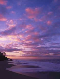 the sun is setting over the ocean with clouds in the sky