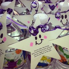 several star shaped water bottles with purple ribbons and tags attached to them, all decorated in different shapes and sizes