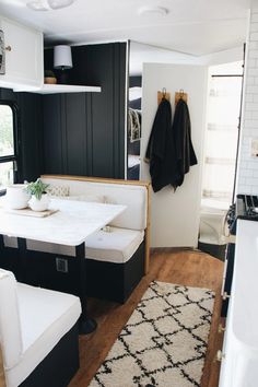 a kitchen with black and white walls, wood floors and a rug on the floor