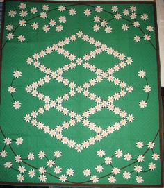 a green quilt with white flowers on it