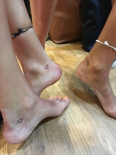 two people with small hearts on their feet and one has a tiny heart tattoo on the ankle