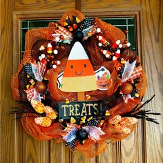 a halloween wreath on the front door decorated with candy