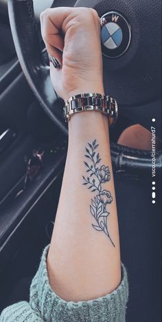 a woman's arm with a flower tattoo on it