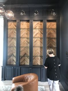 a woman is standing in front of some glass cabinets