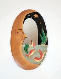 a mirror that has fish in it and a man's face on the side