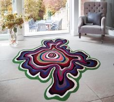 a living room area with a rug on the floor and a chair in the background