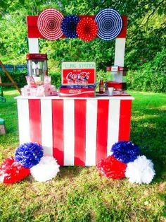 an american flag dessert table with red, white and blue pom poms on it