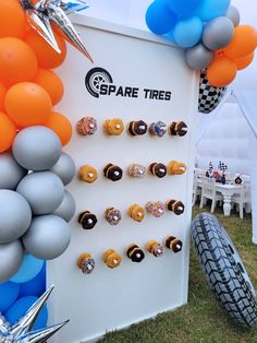 there are many balloons and rings on the wall next to the tire track sign that says spare tires