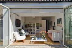 an open living room with two white chairs and a coffee table in front of it