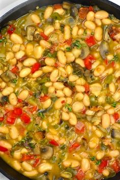 a pan filled with beans and vegetables on top of a stove