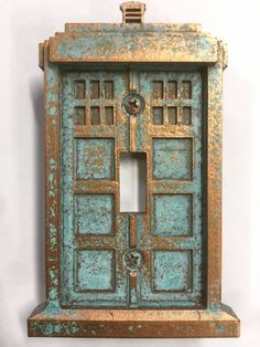 an old metal light switch plate cover in blue and gold color with two doors on each side