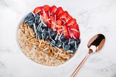 a bowl of oatmeal with strawberries and blueberries