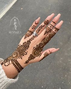 a woman's hand with henna tattoos on it