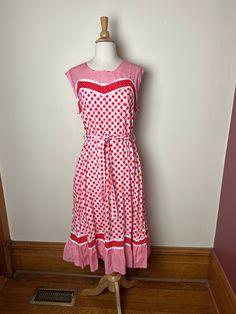 Vintage 70s unbranded picnic core gingham sundress. Straight from Paris! Adorable 70s gingham sundress with sweet lace detailing along bust line and and bottom ruffle. Three different red and white fabrics, mini gingham, large scale gingham and red and white polka dots. Sleeveless, ruffled bottom, zip closure in back. Lovely seaming creates flattering lines for the figure! Sash tie around waist. Hits mid-calf to ankle depending on your height! 100% cotton, no size listed, but would best fit a mo Picnic Gingham Sundress With Ruffles, Polka Dot Summer Dress For Picnic, Spring Gingham Sundress With Ruffles, Polka Dot Dresses For Summer Picnic, Retro Gingham Dress For Picnic, Spring Retro Gingham Dress, Retro Plaid Summer Dress, Retro Cotton Dress For Picnic, Spring Gingham Fitted Sundress