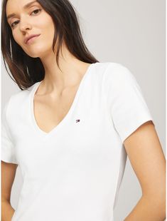 Tommy Hilfiger women's T-shirt. Made from soft, medium weight cotton, our Favorite Tees are designed to fit your form. Another reason to love them? They layer just as easily under a blazer as they do a zip hoodie.  Material: 100% Regenerative Cotton. Trendy Tommy Hilfiger Cotton T-shirt, Tommy Hilfiger Classic Summer Tops, Essential Short Sleeve Summer Tops, Classic Tommy Hilfiger T-shirt For Summer, Tommy Hilfiger Classic Summer T-shirt, Classic Tommy Hilfiger Summer T-shirt, Fitted Tommy Hilfiger V-neck Tops, Tommy Hilfiger Short Sleeve Tops For Spring, Fitted V-neck Tommy Hilfiger Tops