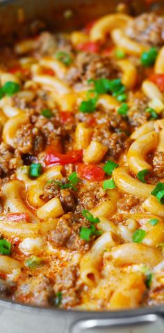 a pot full of pasta with meat and vegetables in it, ready to be cooked