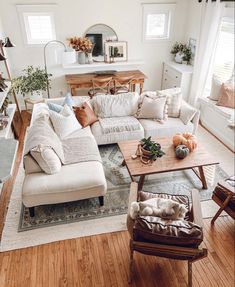 a living room filled with lots of furniture and decor on top of hard wood floors