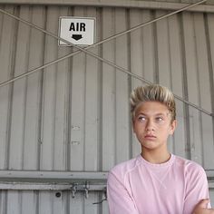 a young man standing in front of an air sign