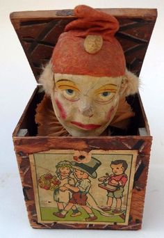 an old wooden box with a doll in it's lid and a painting on the inside