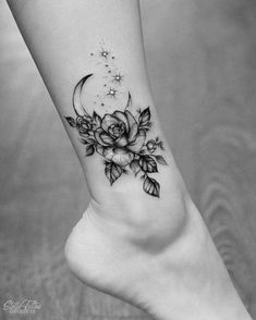 a black and white photo of a woman's foot with flowers on the side