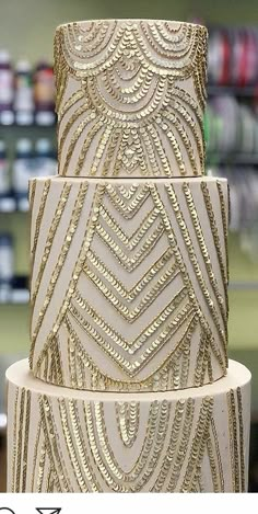 a three tiered cake with gold embellishments