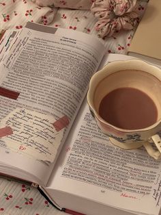 a cup of coffee sitting on top of an open book