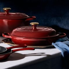 red pots and pans are sitting on a table