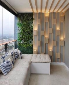 a living room filled with lots of furniture next to a tall wall covered in greenery