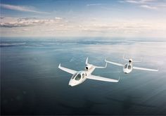 two small planes flying over the ocean