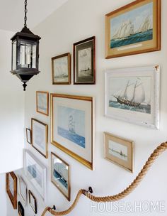 there are many framed pictures on the wall with rope hanging from it's side