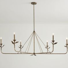 a chandelier with six candles hanging from it's center and leaves on the bottom