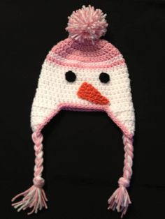 a crocheted hat with a snowman's face on it and a pink pom - pom