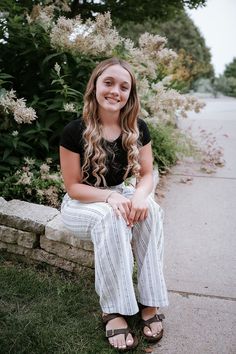 Minneapolis based senior photographer captures photos of a dreamy senior session outside for a girl wearing spring styled outfits including a white dress with sleeves, a short blue dress, and a black tshirt with white and black striped pants. #seniorgirloutfitideas #minnesotaseniorphotographer #minneapolisseniorphotographer #seniorphotoshootinspiration #seniorgirlposes #springseniorphotoshoot