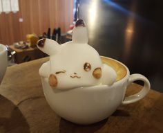 there is a coffee cup with an animal in the foamy liquid on it's face