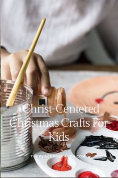 a child is painting with paintbrushes in a tin can and the words christ - centered christmas crafts for kids