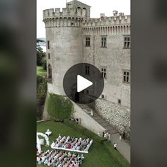 an aerial view of a wedding ceremony in front of a castle