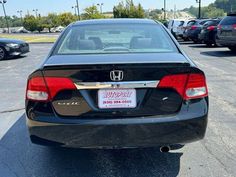 the back end of a black honda accord parked in a parking lot with other cars