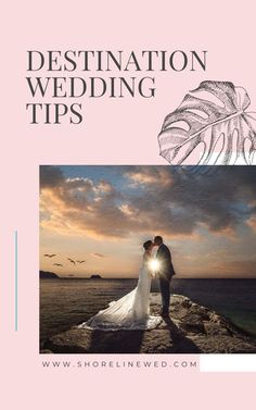 a bride and groom standing on top of a rock next to the ocean at sunset