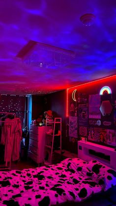 a bedroom with purple and blue lights on the ceiling, cow print bedspread