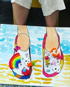 the feet of a person wearing colorful shoes are shown on a painting with watercolors