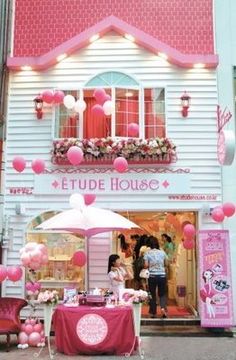 a pink and white house with people standing outside