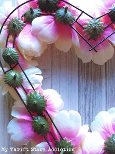 a heart shaped wreath with pink and white flowers