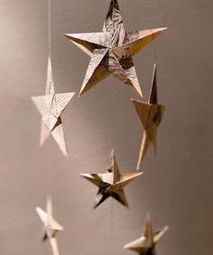 an origami star mobile hanging from the ceiling in front of a white wall