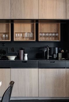 a kitchen with wooden cabinets and black counter tops, along with a dining room table