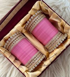 two pink bracelets in a red box on a white furnishing with gold trim