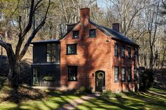 an old brick house surrounded by trees and grass