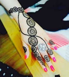 a woman's hand with henna tattoos on it