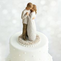 a wedding cake topper with a bride and groom figurine holding each other