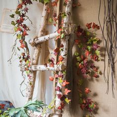 an old ladder is adorned with vines and leaves